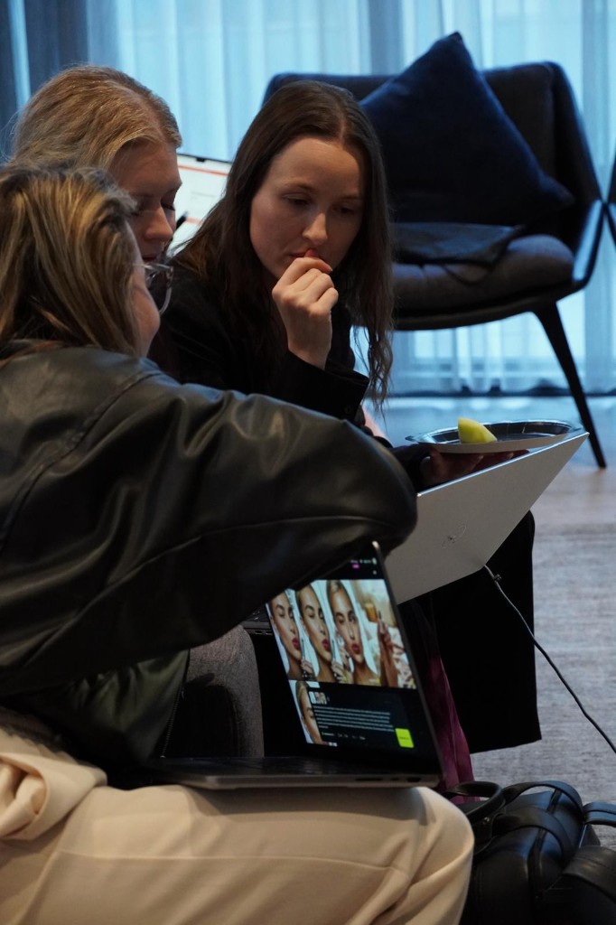 Participants reviewing work together on a laptop